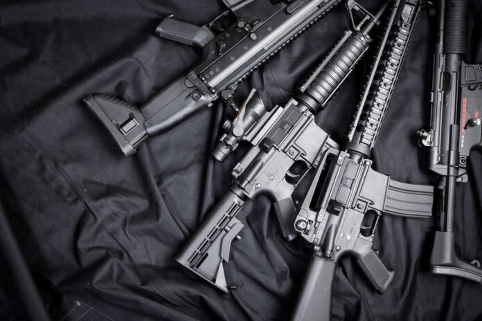 weapon146886211 Black rifles on a dark fabric background