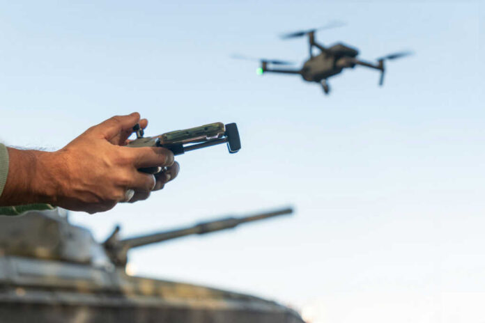 drone-control2430538153jpg Hands holding a drone controller with quadcopter in flight