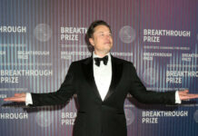 Billion-Dollar Debut, Trillion-Dollar Guess man in a tuxedo posing with arms outstretched at an awards event
