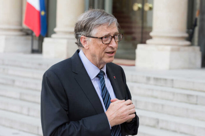 A man in a suit speaking outdoors near a building