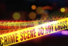 Bartender Butchered — Two Jailed, No Bond Yellow police tape marking a crime scene with blurred lights in the background