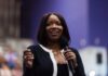 Deadly Weapon Debate Engulfs Lawmaker’s Remarks A woman speaking into a microphone with a smile