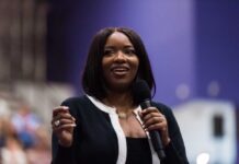 A woman speaking into a microphone with a smile