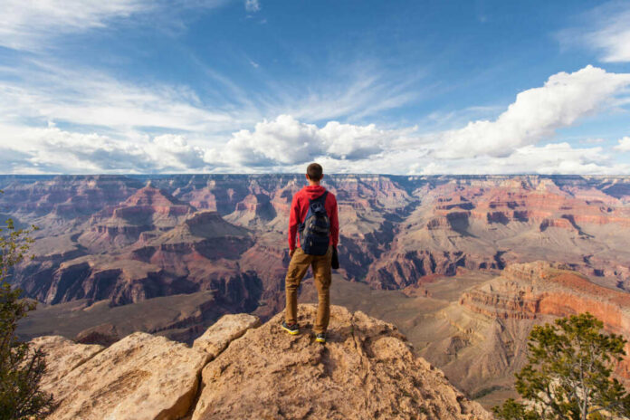 travel-in-grand-canyon-man-hiker551351365jpg-1 Hiker overlooking expansive canyon landscape