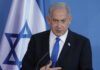 Netanyahu Says The Buffer Zones Remain Man speaking in front of Israeli flag backdrop