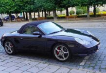 Black convertible sports car parked on cobblestone street