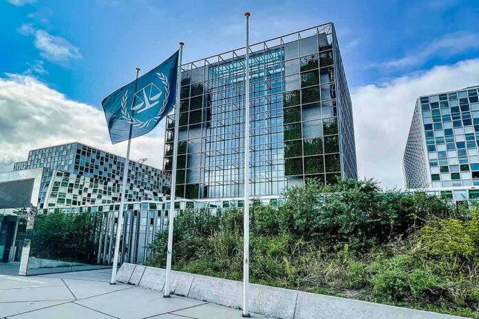 Modern glass office building with blue flag and greenery