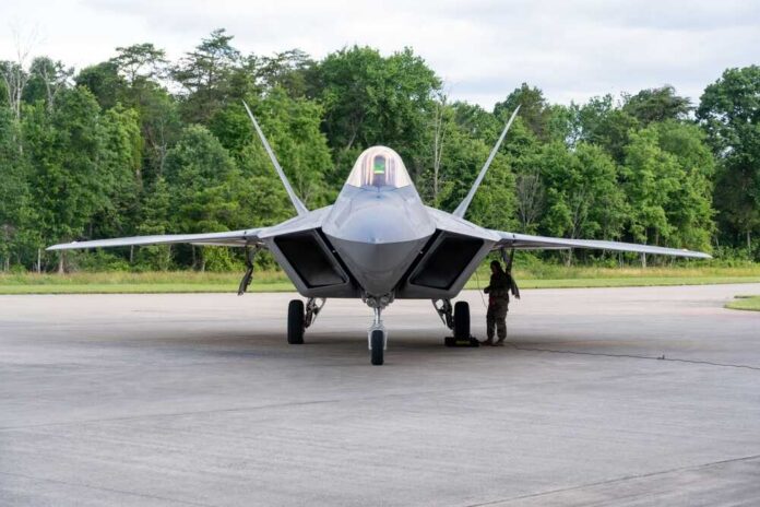 Dull,,Us,-,Jun,06,,2023:,A,Vintage,Us,Airforce F-22 Raptor military aircraft on the tarmac with a crew member performing maintenance