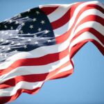Waving American flag against a clear blue sky