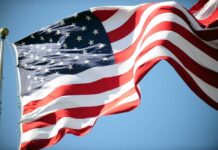 Waving American flag against a clear blue sky