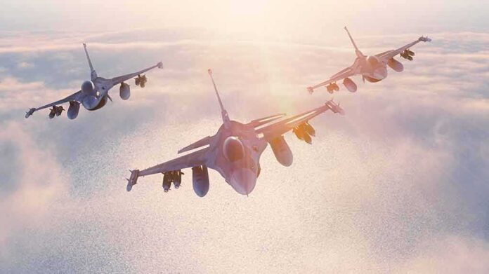 shutterstock_405633937 Three fighter jets flying in formation above clouds at sunrise