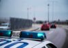 One Forgotten Alert Put Innocent Drivers At Gunpoint Police car with blue lights on near a roadway