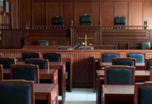 Planning Or Psychosis? Jurors Face Haunting Question Empty courtroom with wooden benches and judge's bench
