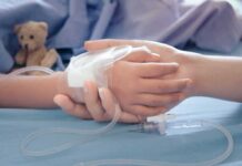 One Neighborhood. One Rare Cancer. Many Questions. Child's hand with IV line held by another hand