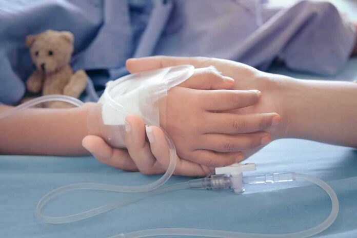 Child's hand with IV line held by another hand