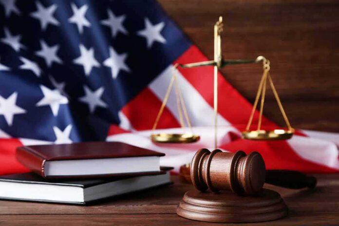 Gavel, law books, and scales with American flag background