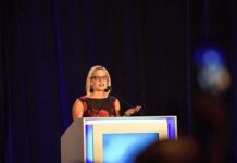 Woman speaking at a podium on a stage