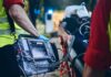 Paramedic with defibrillator beside patient on stretcher
