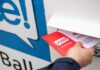 Hand inserting mail-in ballot envelope into drop box