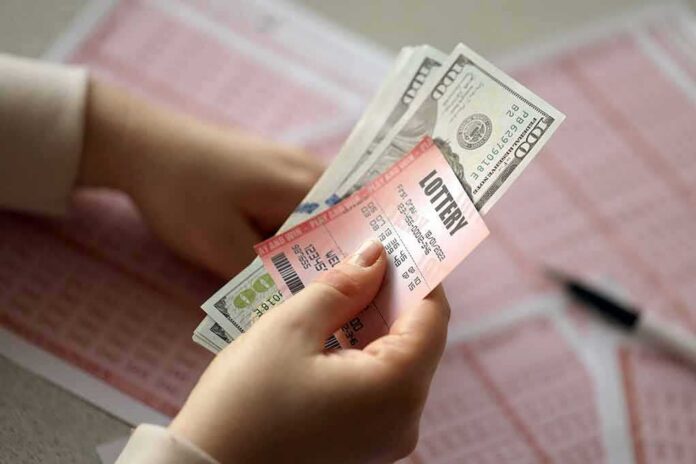 shutterstock_2155913955 Hands holding lottery tickets and U.S. dollar bills