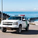 Border patrol SUV parked near beach fence