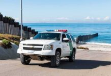 Nighttime Rescue Exposes Border Reality Border patrol SUV parked near beach fence