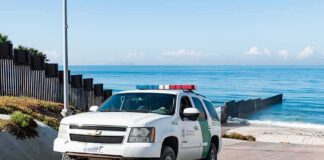Border patrol SUV parked near beach fence