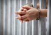 China’s Agent Exposed—Inside America hands in handcuffs behind jail bars