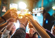 group toasting with beer glasses in a pub