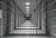 empty prison corridor with barred cells