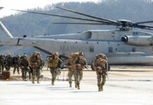 After Two Decades, America Is Finally Leaving Soldiers disembark and walk past a large military helicopter