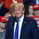 Donald Trump at a rally speaking at a microphone