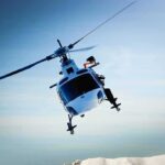 helicopter banking over snowy mountains