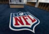 The NFL Made A Demand. Washington Pushed Back NFL logo on the floor of an empty locker room