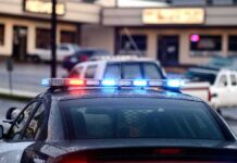 Gunfire Scare Halts Miami Departures Police car with flashing red and blue lights in a parking lot