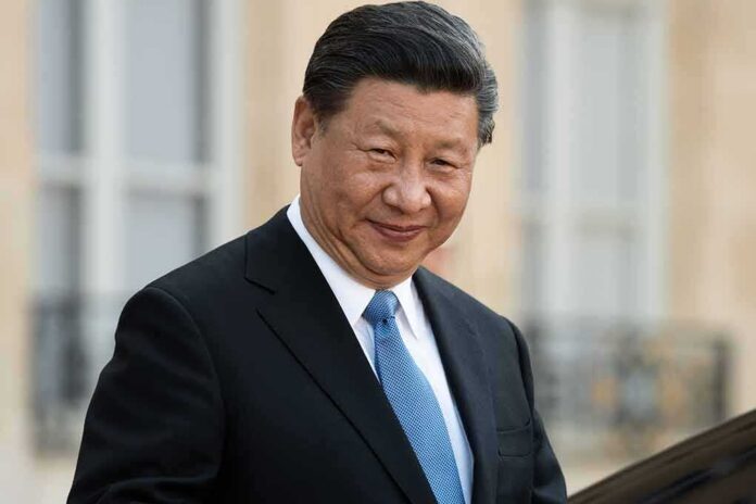 shutterstock_1353005387 Xi Jinping in a dark suit with a blue tie, smiling outdoors