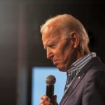 Joe Biden speaking into a handheld microphone on stage