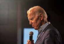 Joe Biden speaking into a handheld microphone on stage