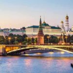 Moscow Kremlin skyline at dusk with illuminated bridge over river