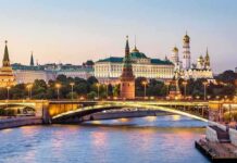 Moscow Kremlin skyline at dusk with illuminated bridge over river
