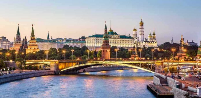 Moscow Kremlin skyline at dusk with illuminated bridge over river