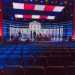 SNL’s Outrageous Joke Tradition Exposed Debate stage with red and blue lighting and empty audience seats