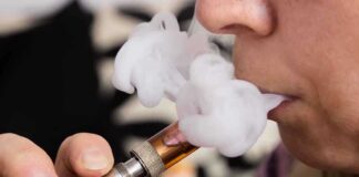 Close-up of a person vaping, exhaling smoke clouds