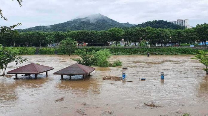 shutterstock_1786013174 Rising floodwaters submerge riverside park shelters