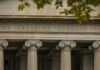 Neoclassical building facade with Ionic columns and engraved frieze