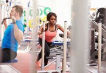 Brain Ticking Time Bomb Strikes Young Athlete Woman performing sled push in a gym beside a man using a cable machine