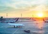 Airplanes on airport tarmac at sunset