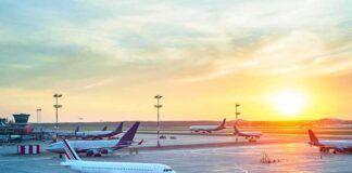 Airplanes on airport tarmac at sunset
