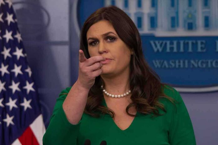Woman at press briefing pointing toward audience