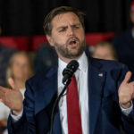 Hard-Liner Targeted – Nuclear Talks Teed Up Man in suit speaking at a podium